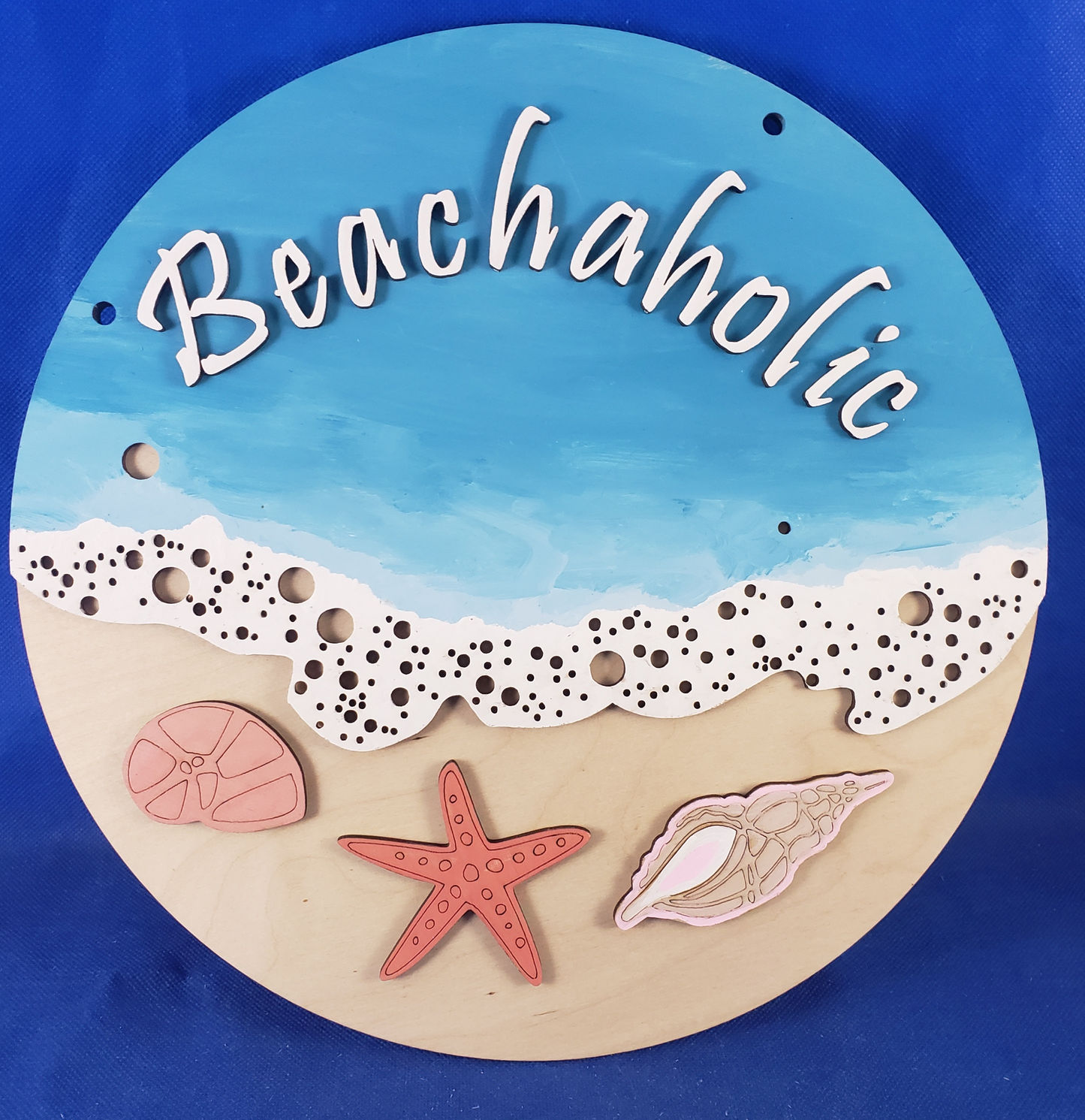 a wooden plaque with a picture of a beach and starfish