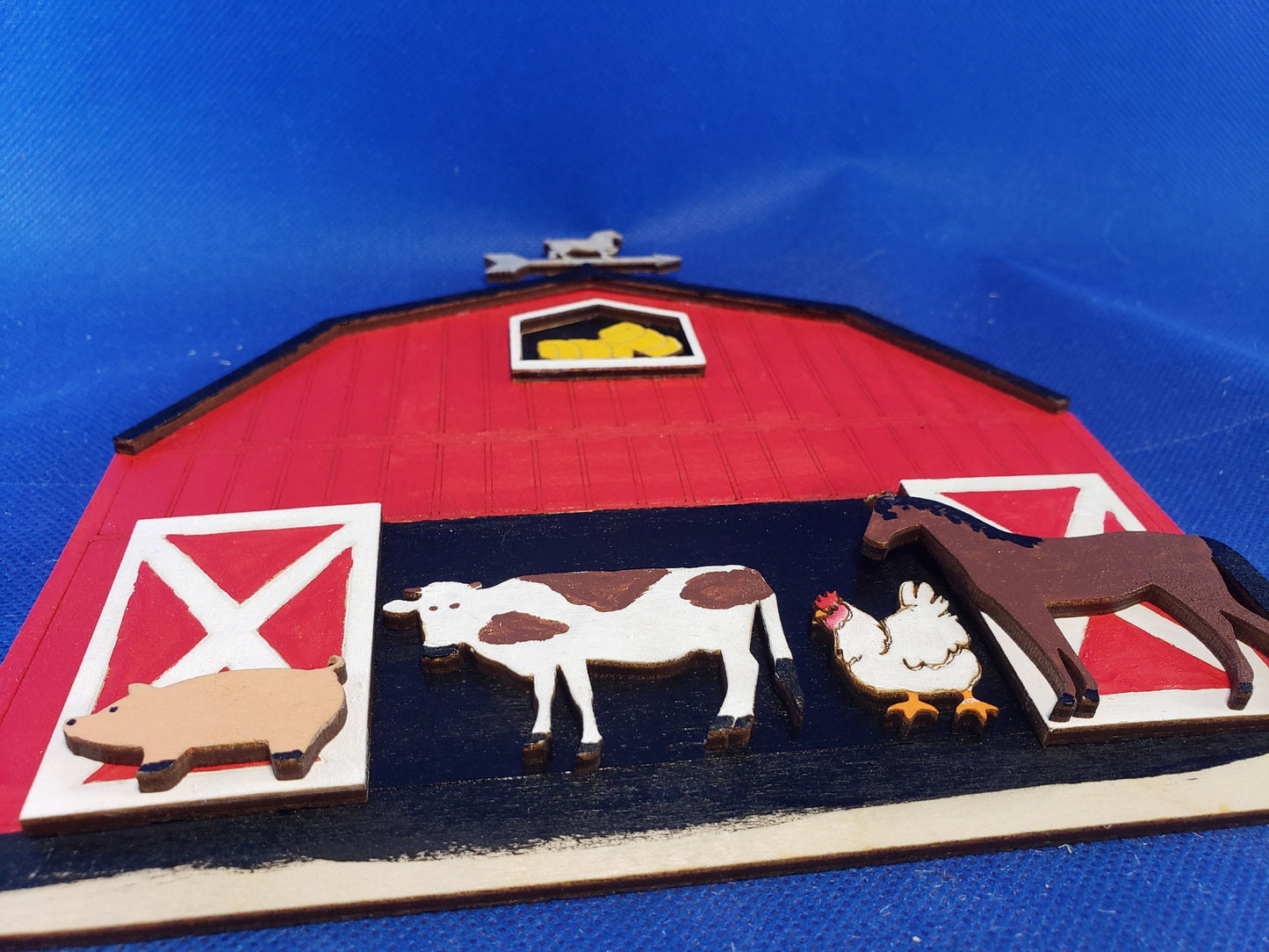 a toy farm scene with farm animals and a barn